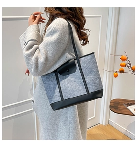 Sac fourre-tout en feutre gris avec garniture en cuir noir porté par un mannequin de côté