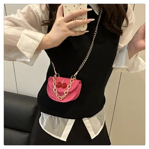 Pink semi-circular mini bag with cherry charms and gold chain straps shown on model