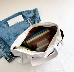 Detail view of the spacious white nylon tote bag interior with multiple storage compartments