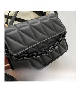 Detail showing black quilted faux leather texture and thick fashion chain decoration