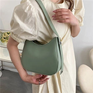 Détail du sac hobo en cuir vert clair avec boucle argentée réglable sur la bandoulière
