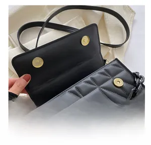 Detail shot of the secure magnetic snap closure on a black quilted chain bag