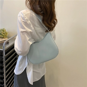 Sac hobo croissant bleu clair minimaliste porté par un mannequin pour le style quotidien