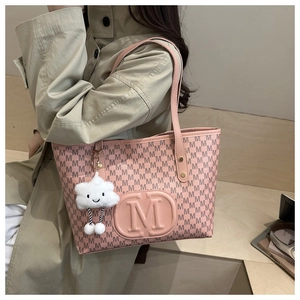 Detailed texture of pink tote bag with letter patterns and a cloud plush charm accessory