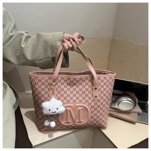Pink tote bag detail with repeating M pattern, 3D logo and cloud-shaped plush charm