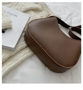 Sac croissant en similicuir marron avec large bandoulière et base arrondie élégante