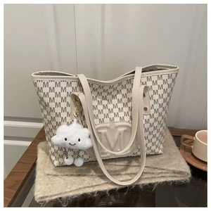 Macro shot of beige tote bag with M-pattern texture and white plush cloud charm detail