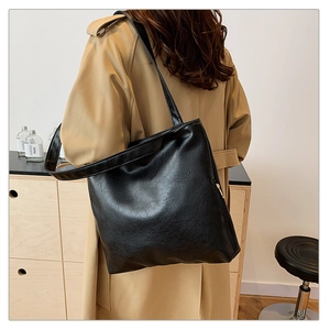 Detail of black tote bag with vintage wrinkled texture and sturdy wide shoulder strap