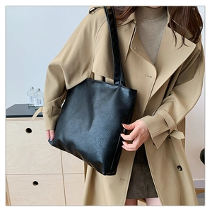 Detailed view of a soft black PU leather tote bag with elegant wrinkled texture finish