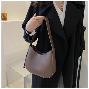 Gros plan d'un sac hobo minimaliste marron moka avec finition en cuir mat lisse