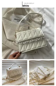 Macro view of white flap crossbody bag with triangle quilting and chunky chain