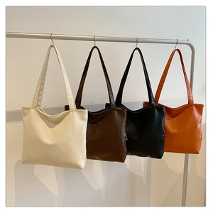 Macro display of minimalist tote bags in four colors hanging on a steel display rack
