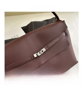 Detail of the silver twist lock and leather strap closure on a dark brown bag