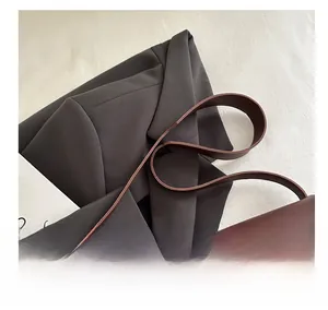 Detail view of the red leather handbag featuring a classic silver buckle and smooth finish