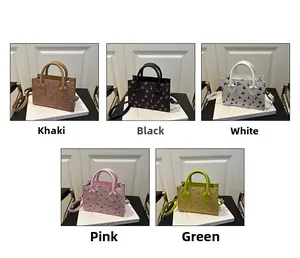 Close-up of five cherry print bags in khaki, black, white, pink and green finishes