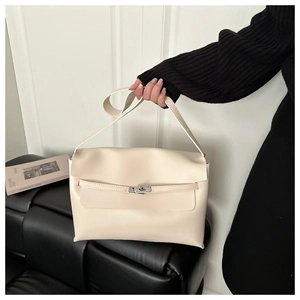 Detail of a minimalist cream white leather handbag with a metallic turn-lock and strap