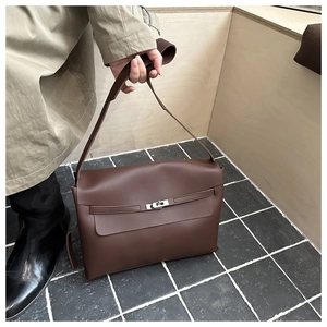 Detailed close-up of brown leather bag with silver metal twist lock and strap detail