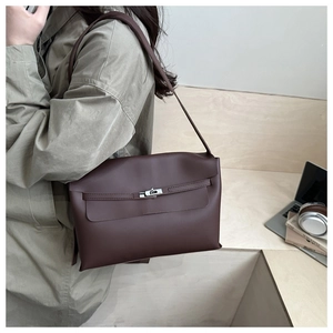 Detail of deep brown shoulder bag showing metal twist lock and supple leather texture
