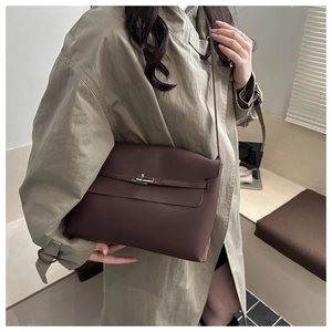 Detailed close-up of dark brown leather handbag with silver metallic twist lock closure