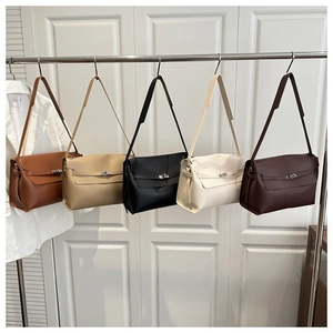 Row of minimalist shoulder bags in five colors hanging on a modern metal rack