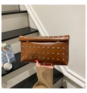 Detailed view of a vintage brown envelope clutch bag with silver metallic stud accents
