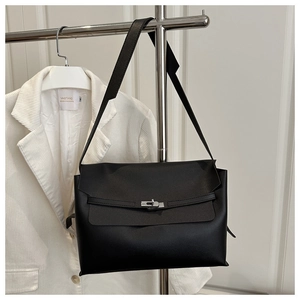 Detail of black matte synthetic leather bag with silver twist lock and wide strap