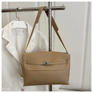 Detail of tan leather shoulder bag with classic metal swivel lock and flap closure