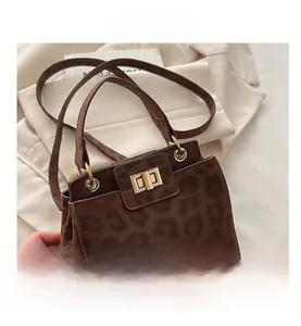 Détail d'un sac à main léopard avec fermoir doré tournant et texture effet velours