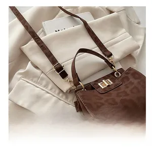 Détail du sac à main léopard avec fermoir rotatif doré et bandoulière réglable