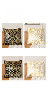 Detail of four geometric gold foil cushion covers in black and white velvet on a sofa
