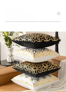 Detail of retro geometric gold stamping on plush black and white cushion covers