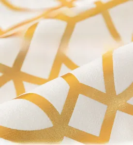 Close-up of soft plush fabric with gold geometric lines on a white cushion cover