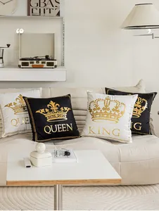 Detail of gold foil crown and King Queen lettering on plush black and white pillow covers