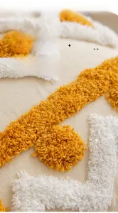 Detail of tufted mustard yellow and cream cotton cushion cover with artistic embroidery