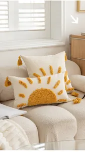 Detail of tufted sun pattern embroidery and yellow tassels on boho throw pillow cover