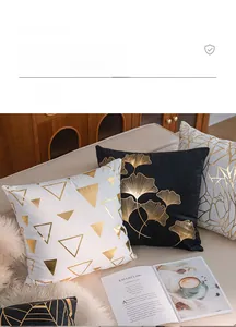 Detail of luxury gold foil leaf and geometric patterns on plush cushion covers