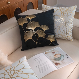 Luxurious velvet pillow covers with gold gingko leaf and geometric patterns on sofa