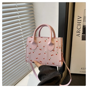 Detailweergave van roze mini kussentas met kersenprint en zachte PU-lederen handvatten