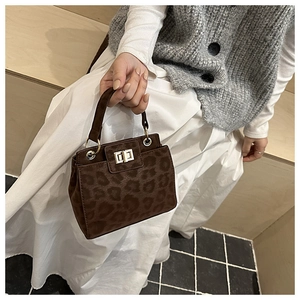 Détail du sac léopard avec fermoir rotatif argenté et texture en cuir suédé mat