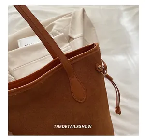 Detail der braunen matten Shopper-Tasche mit glatter Lederpaspel und verstärktem Riemen