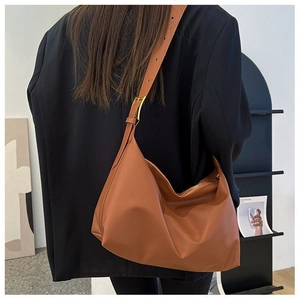 Close-up of a brown leather Hobo shoulder bag with adjustable strap and gold hardware