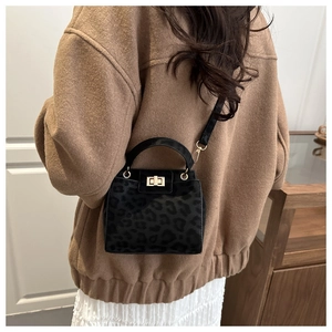 Détail du sac léopard avec fermoir rotatif doré et poignée supérieure chic