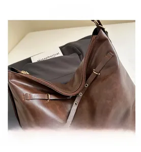 Detail view of large brown PU leather tote with metal eyelets and premium texture