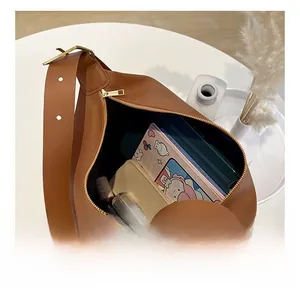 Internal view of spacious brown leather tote showing ample storage for books and electronics