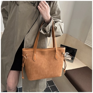 Detailansicht der karamellfarbenen Wildleder-Tasche mit Tunnelzug und goldenem Ring