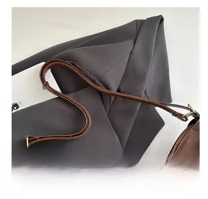 Detailed macro view of vintage brown leather tote bag with metal zipper and strap