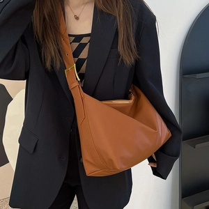 Detail of caramel brown leather tote bag with gold adjustable buckle and zipper closure