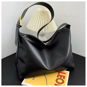 Detail of matte black tote bag with golden square buckle and adjustable strap