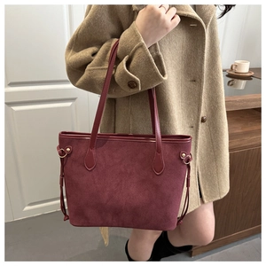 Detailaufnahme der burgunderroten Wildledertasche mit Goldring und matter Textur