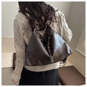Macro detail of dark coffee tote bag with soft leather texture and metal eyelet straps